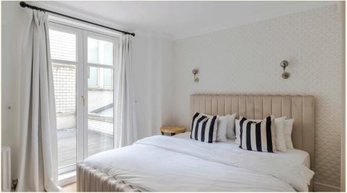 伦敦Maddox House的白色的卧室设有一张大床和一个窗户