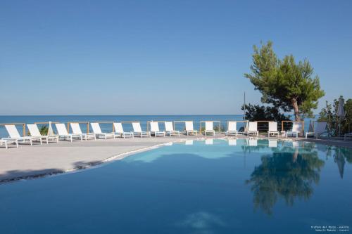 马蒂纳塔AH Premium Baia dei Faraglioni的一个带椅子的游泳池,背景是大海