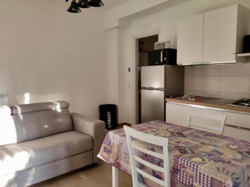 罗马Tiny Green apartament in Rome - Magliana的带沙发和桌子的客厅以及厨房。