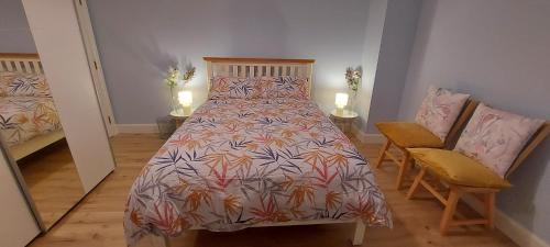 班特里Captivating 3-Bed House的一间卧室配有一张床、两把椅子和两盏灯。