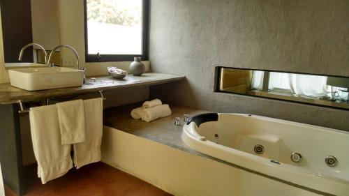 迪坡斯特兰奇迹精品酒店的一间带大浴缸和水槽的浴室