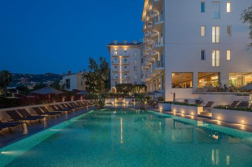 索伦托Hotel Conca Park的夜间在建筑前的游泳池