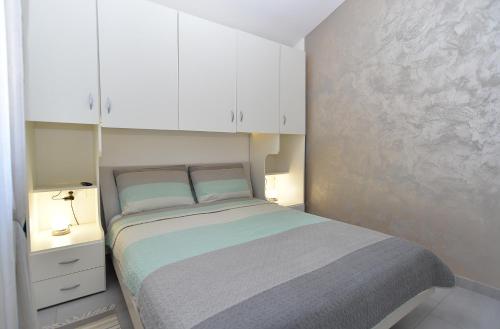佩罗杰House Peroj 2195的一间小卧室,配有一张床和白色橱柜