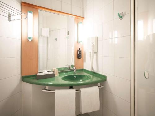 弗里堡弗里堡宜必思酒店的一间带绿色水槽和镜子的浴室