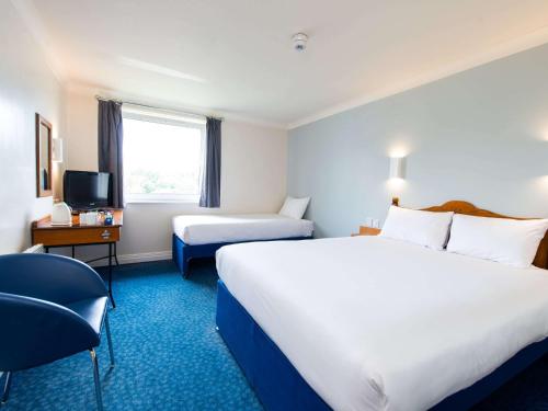 格拉斯哥ibis budget Glasgow Cumbernauld的酒店客房设有两张床和电视。
