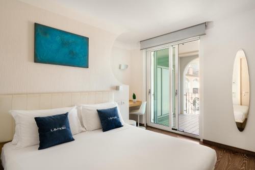 雷卡纳蒂港Life Hotel Seaview & Spa的卧室配有带蓝色枕头的大型白色床