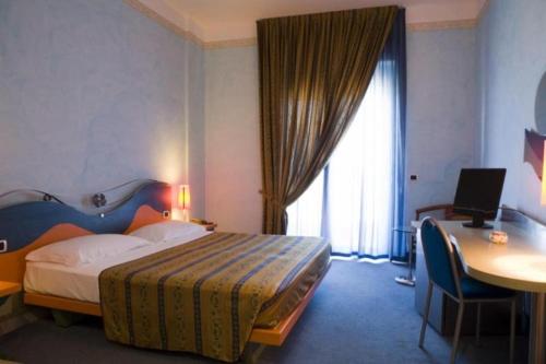 玛格丽塔萨沃亚Hotel Del Sole的酒店客房配有一张床和一张带电脑的书桌
