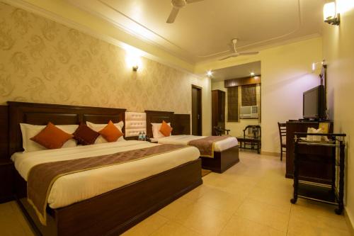 新德里Hotel Grand Park Inn的酒店客房设有两张床和电视。