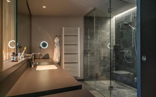 巴特埃姆斯Emser ThermenHotel的带淋浴、盥洗盆和浴缸的浴室