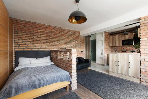 布达佩斯Industrial Studio的砖墙卧室配有一张床和一间厨房