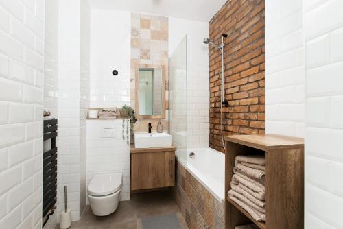 布达佩斯Industrial Studio的浴室配有盥洗盆、卫生间和浴缸。