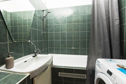 布达佩斯The Sunlight Studio的绿色瓷砖浴室设有水槽和淋浴