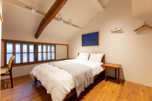 出云市MACHIYA HOTEL madoka - Vacation STAY 65847v的一间卧室配有一张大床和一张桌子