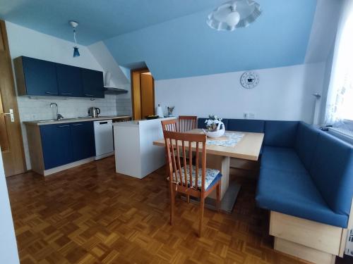 波希基斯卡贝拉Fantastic Apartment Brglez的厨房配有蓝色的沙发和桌椅