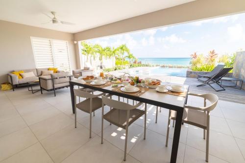 勒迪亚芒Eden Roc Villas的一间设有桌子的海景用餐室