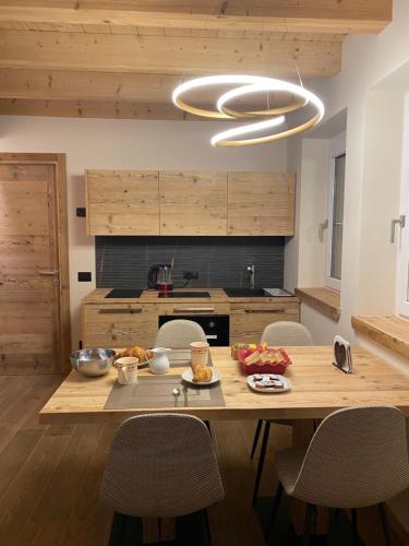 加廖Il Falco Affittacamere的厨房配有带椅子的木桌和大吊灯。