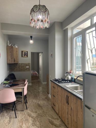第比利斯Apartments on Bakradze的厨房配有吊灯、水槽和桌子