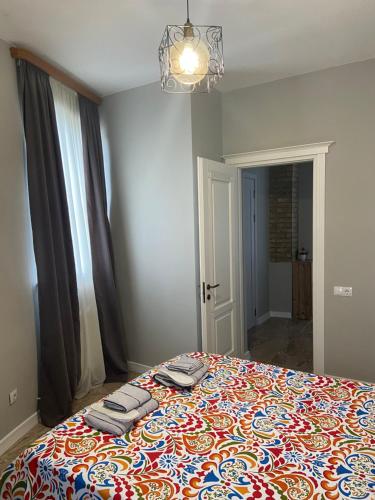 第比利斯Apartments on Bakradze的一间卧室配有一张带彩色毯子的床