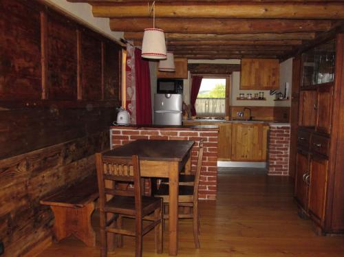 奥斯塔Alloggio Gran Paradiso的厨房配有木桌和椅子