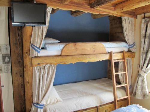 奥斯塔Alloggio Gran Paradiso的配有两张双层床的客房设有平面电视。