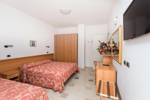切塞纳蒂科Hotel Residence Des Bains的酒店客房设有两张床和一台平面电视。