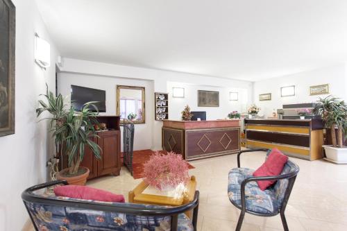 切塞纳蒂科Hotel Residence Des Bains的客厅配有两把椅子和电视