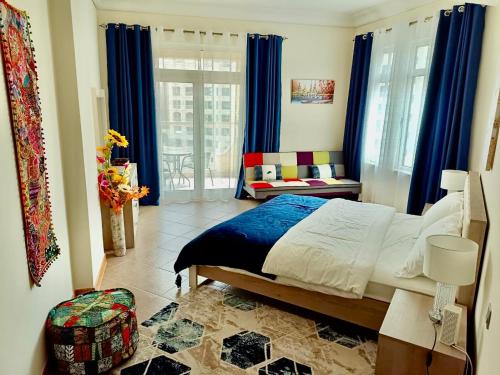 迪拜Luxury Apartment Palm Jumeirah的一间卧室配有床和蓝色窗帘的窗户
