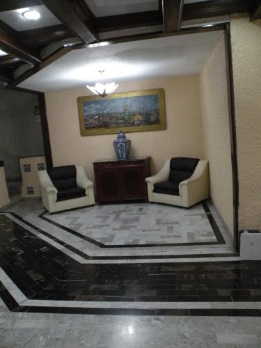 普埃布拉阿里斯托斯普布拉的客厅配有两把椅子和镜子