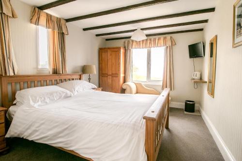 布里克瑟姆Raddicombe Lodge的一间卧室设有一张大床和一个窗户。