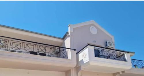 斯卡拉拉乔伊Xanthiotis Apartments的带阳台的白色房屋和蓝色天空
