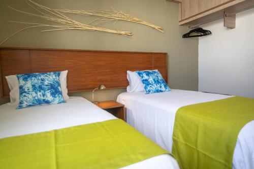 莫雷洛斯港Casa Tucan. A contemporary holiday or work nest的两张睡床彼此相邻,位于一个房间里