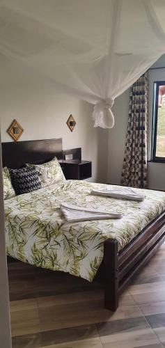 GilgilLala Inn Kikopey的一间卧室配有一张带天蓬的大床