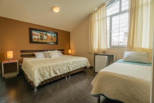 利马B&B Wasi Airport Lima的酒店客房设有两张床和窗户。