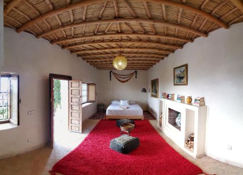 乌鲁卡ourika oufla的一间铺有红色地毯并配有一张床的客厅