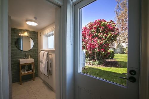 杰拉尔丁The Vicarage Geraldine的浴室门享有一棵带粉红色花卉的树的景致