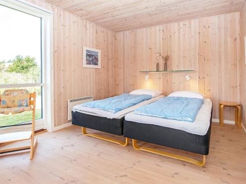乌尔夫堡Holiday home Ulfborg XXII的木墙客房的两张床