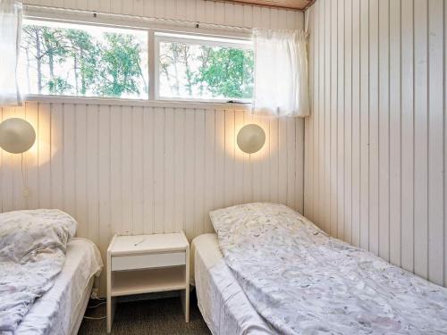 维斯特索马肯Holiday home Aakirkeby XXXII的一间卧室设有两张床和窗户。