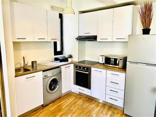 拉纳卡BALI SUITES 303的厨房配有白色橱柜、洗衣机和烘干机