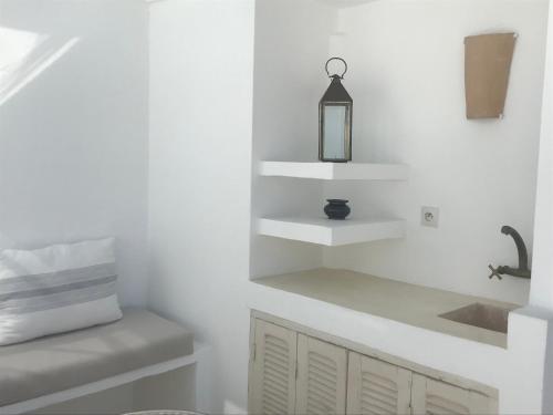丹吉尔Dar 23的厨房设有白色的墙壁、水槽和架子