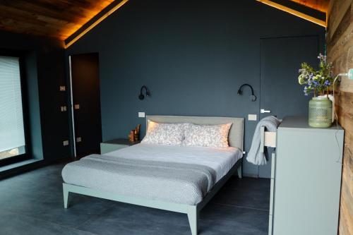 格雷桑Le Volpi Luxury Apartments的一间卧室设有一张床和蓝色的墙壁