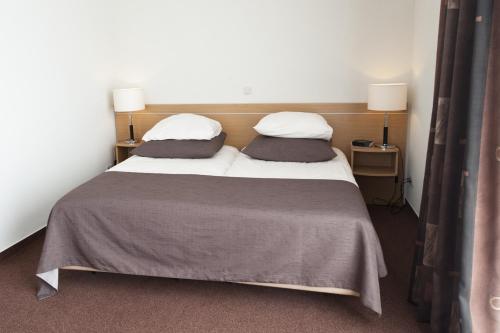 内斯阿默兰酒店的两张位于房间的床,配有两个枕头