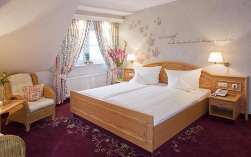 不莱梅罗宾酒店的一间卧室配有一张大床和一把椅子