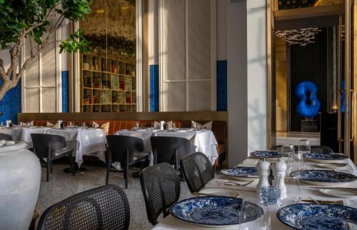利雅德Jareed Hotel Riyadh的一间设有白色桌椅和蓝色盘子的餐厅