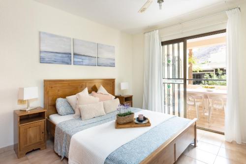 洛斯克里斯蒂亚诺斯Home2Book Charming Castle Harbour Los Cristianos的一间卧室设有一张床和一个阳台