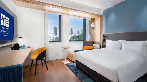 北京北京通州旅游度假区智选假日酒店的配有一张床、一张书桌和一扇窗户的酒店客房