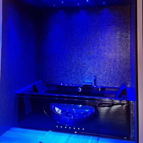 法雷诺Dolce&casanova的蓝色的浴室设有蓝色的灯光浴缸