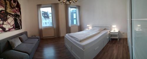 锡格堡Siegburg Apartment 1的一间卧室配有一张床、一张沙发和一个窗口