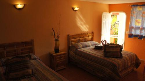 图拉德阿连德Hotel Posada Tolteca的一间卧室设有两张床和窗户。