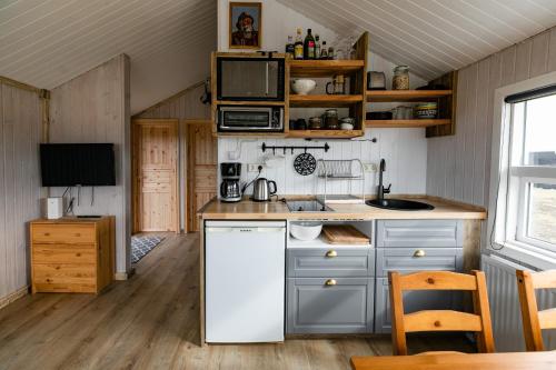 Sandgerði桑德格迪小屋酒店的一间厨房,内配白色冰箱