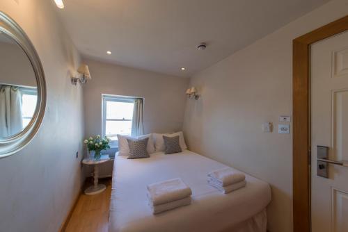 伦敦百乐门酒店的一间小卧室,配有白色的床和两个枕头